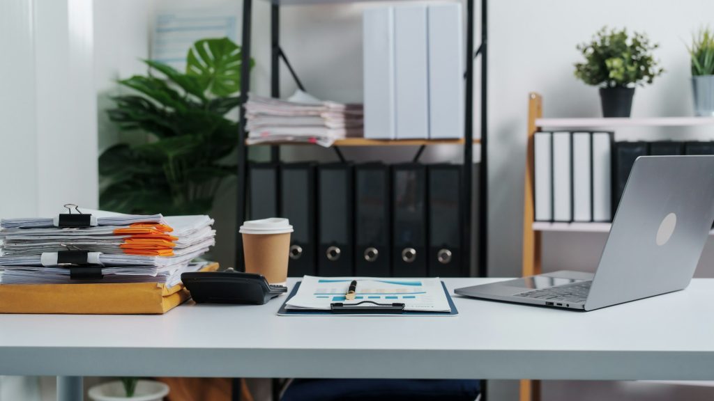 Stylish workspace with laptop, notebook, blank screen laptop on white table of bookkeeping.